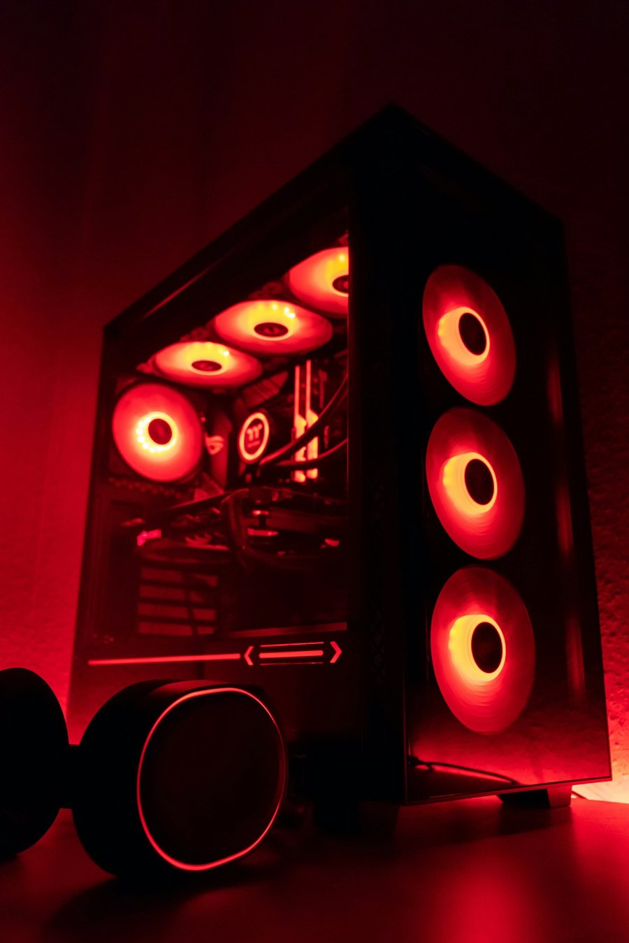 Black mid-tower PC lit red, front and top fans glowing